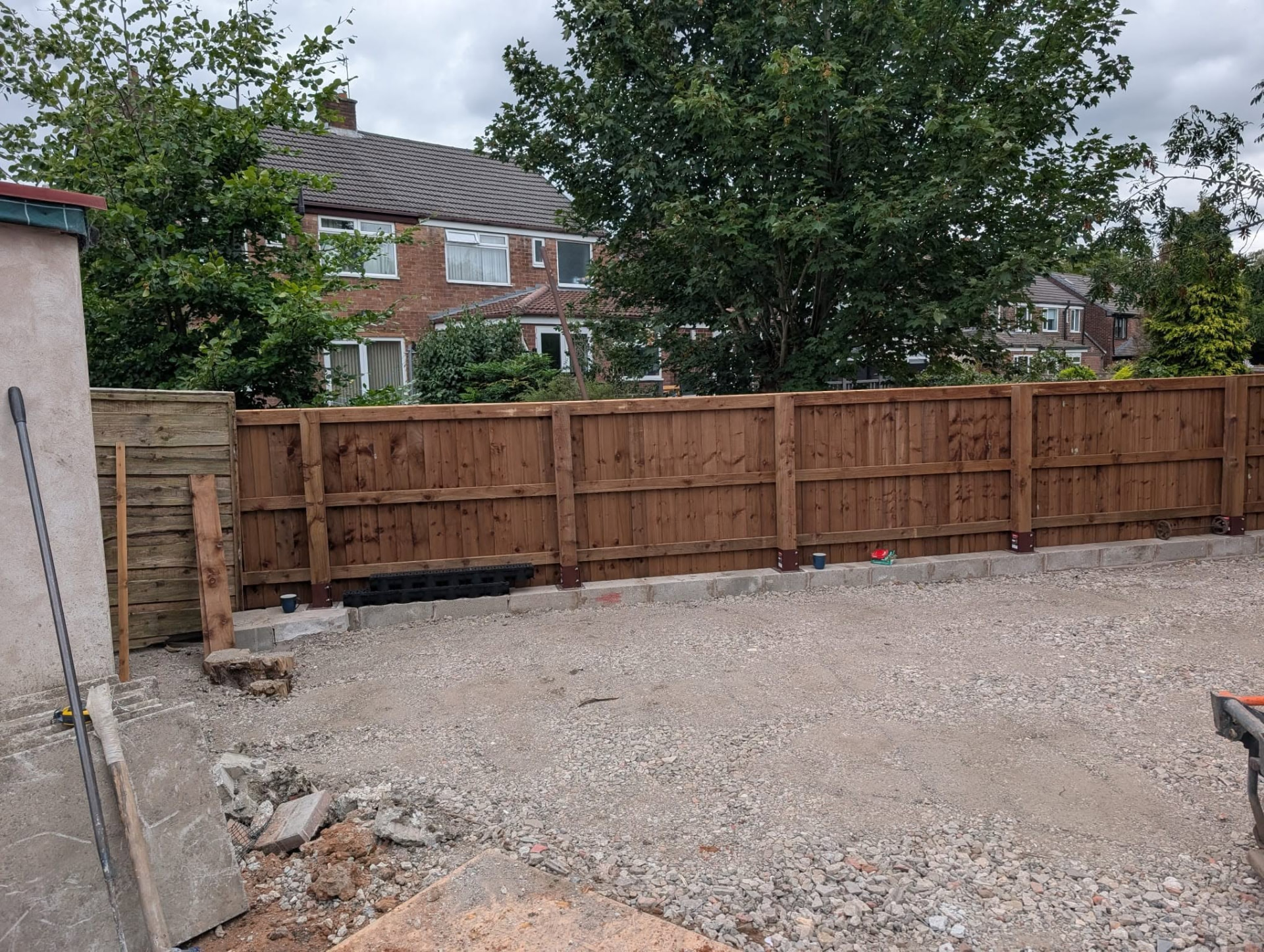Compacted stone sub-base with a block footing and new timber fence panels
