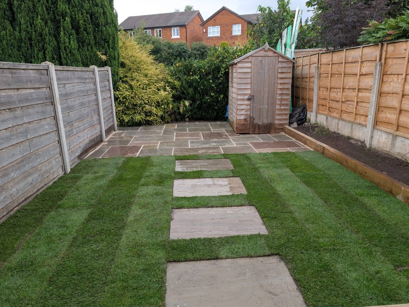 Finished garden with natural stone paving, stepping stones and newly laid turf