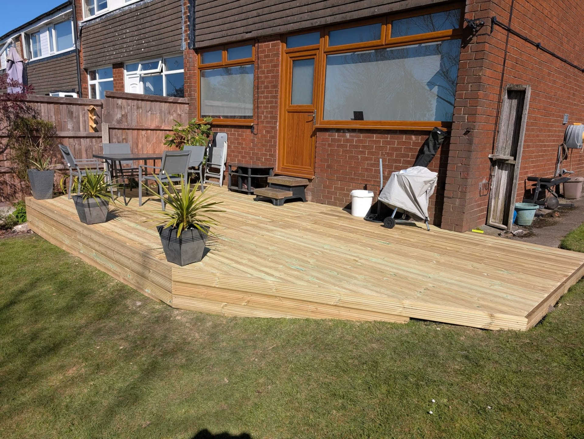 Elevated timber decking platform wrapping around the rear of a house